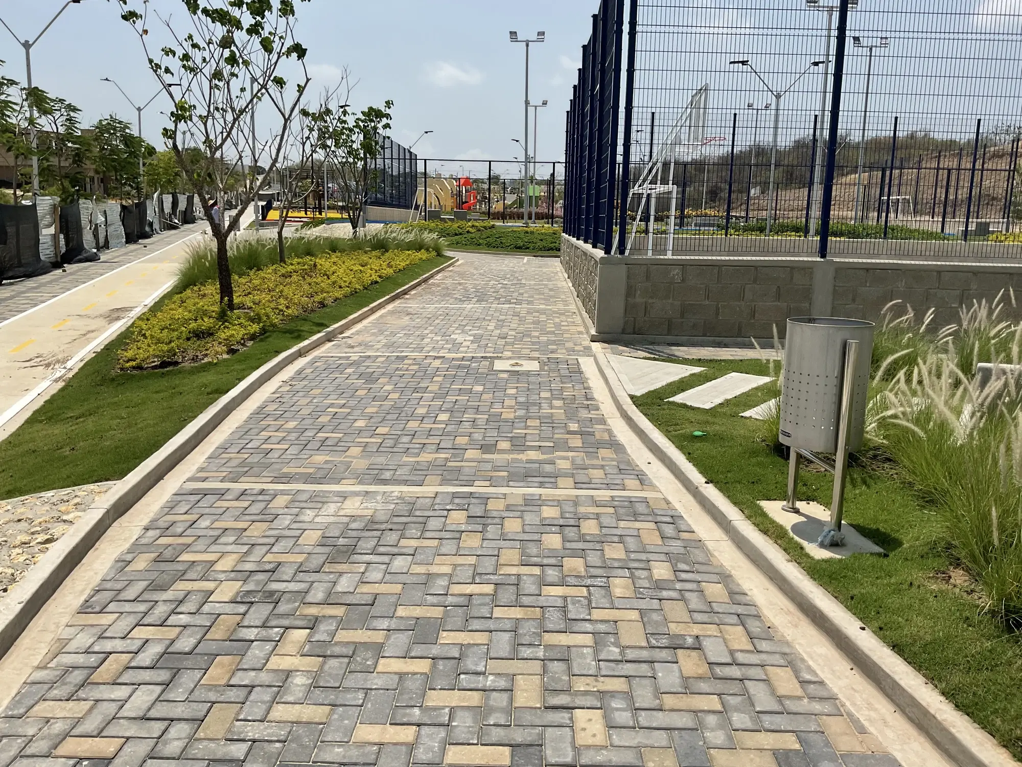 Corredor peatonal junto a canchas deportivas y arborización nativa